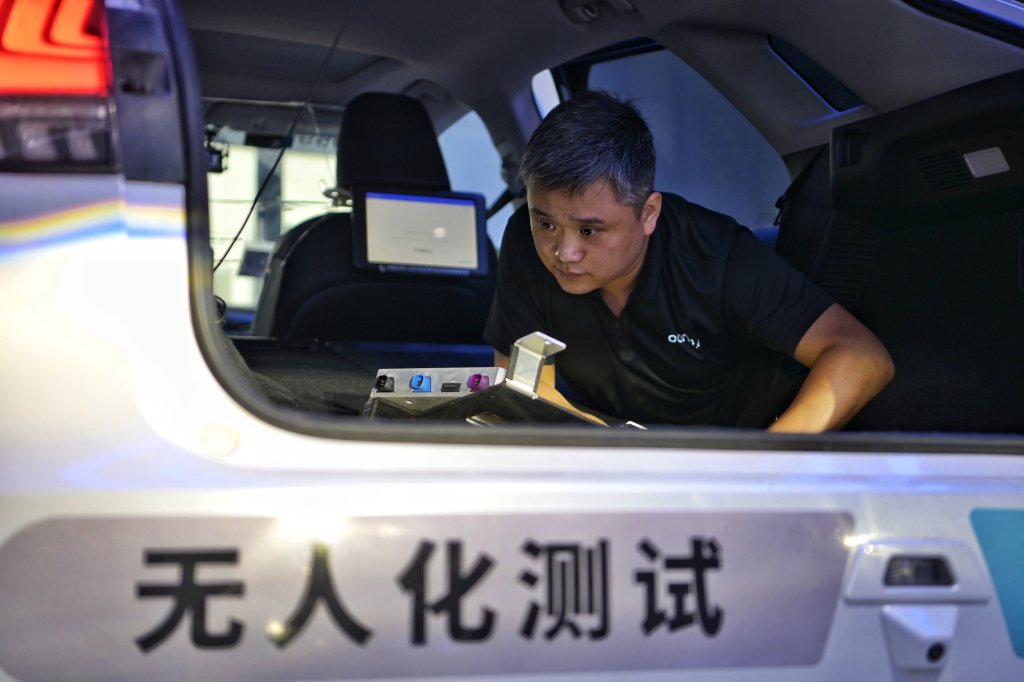 在位于北京自动驾驶示范区的小马智行亦庄运营中心内，工作人员在检查一台自动驾驶测试车辆内的传感器设备。新华社资料图